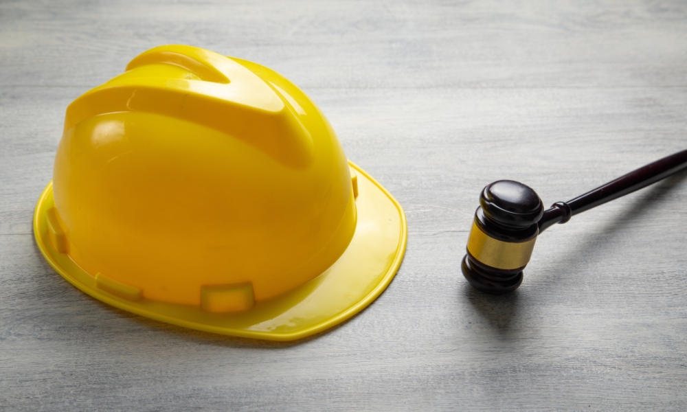 Yellow hard hat and judge’s gavel shown in a workplace safety case