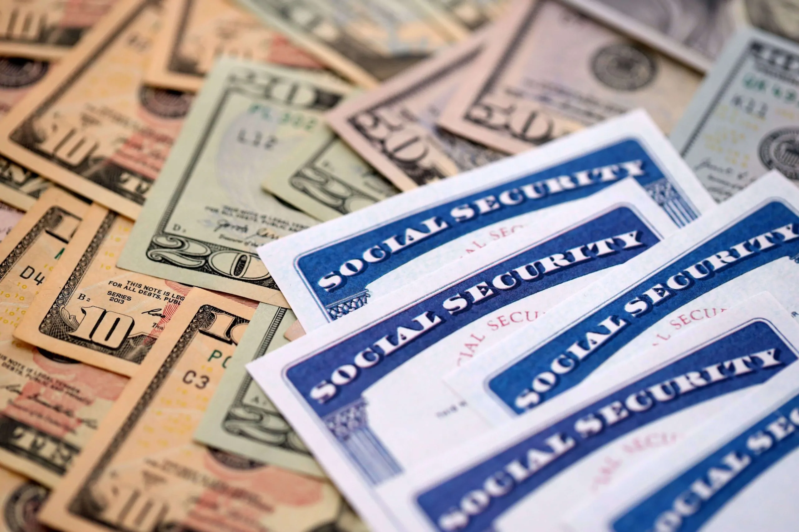 Social security number cards on many US dollar money bills close up