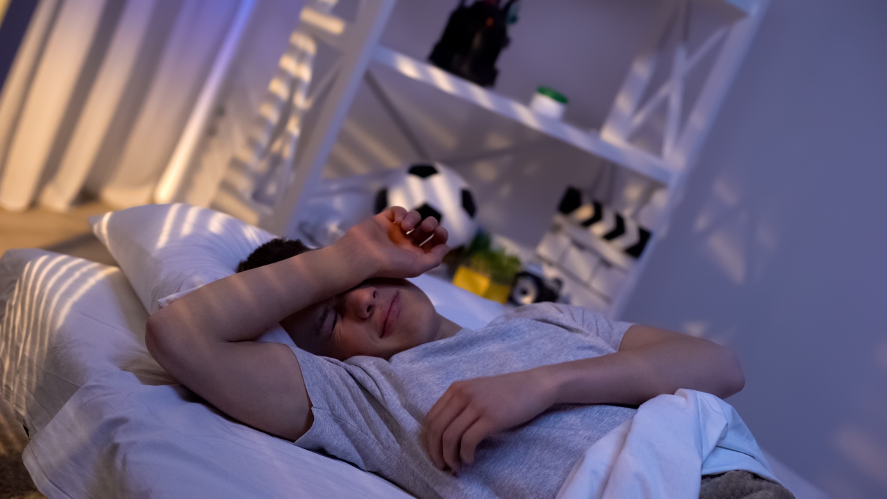 Teen lies awake in bed during a night of poor sleep