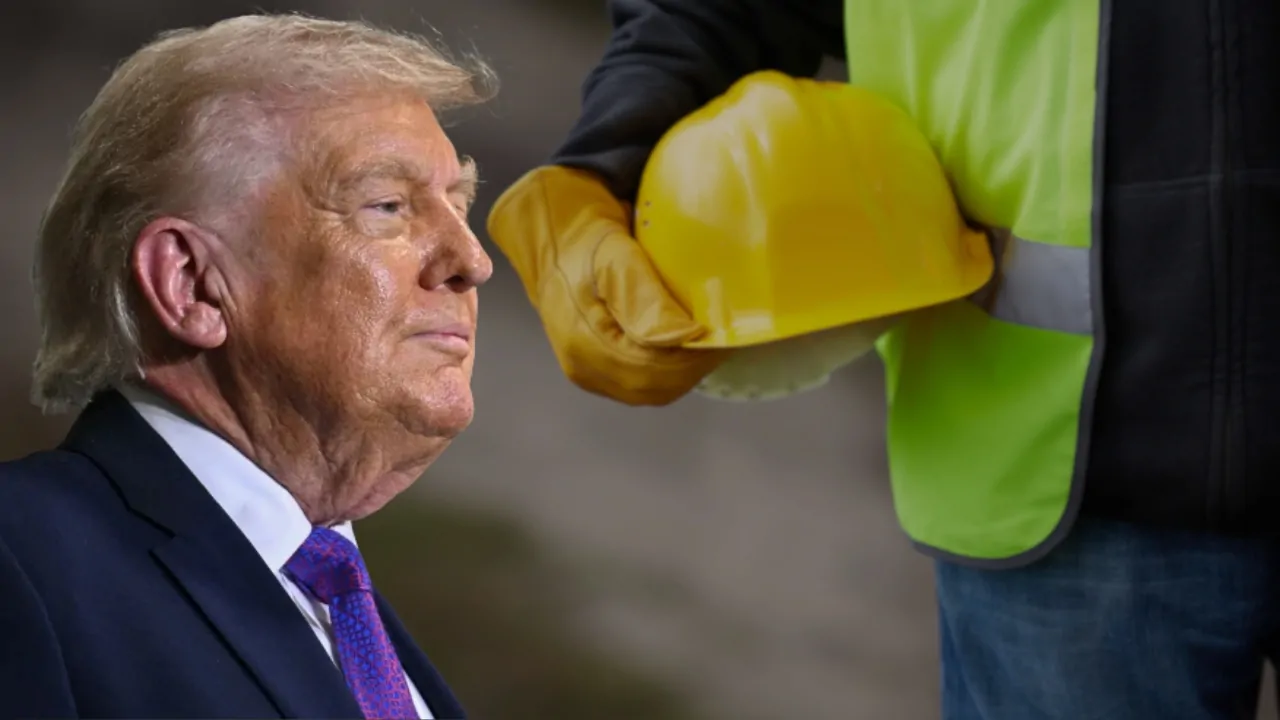 Trump sits beside a construction worker holding a yellow hard hat