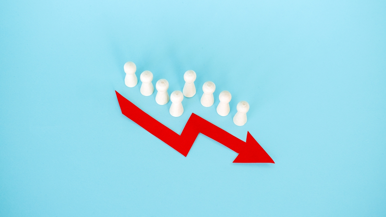 White figures stand above a red downward arrow to show population decline