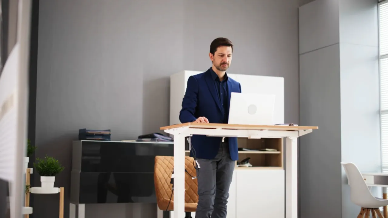 Man works at a stand-up desk in a modern office