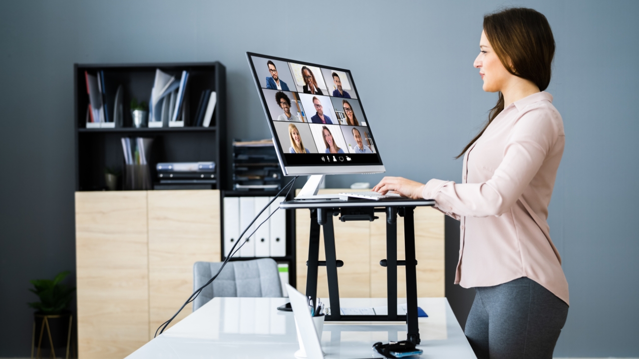 Woman works at a raised desk on a video call