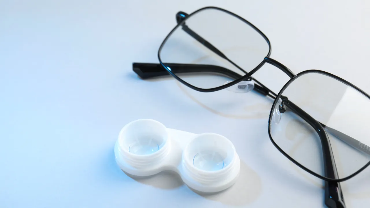 Glasses and a contact lens case sit on a white surface