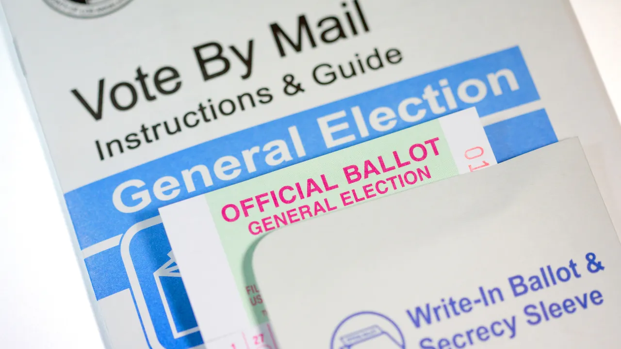 Vote-by-mail instructions and an official ballot sit inside a ballot envelope