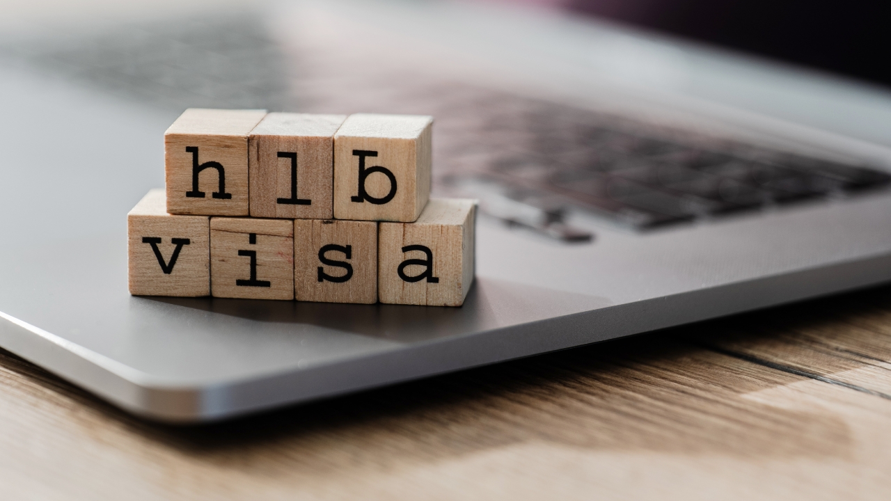 Wooden blocks spell H-1B visa on a laptop keyboard