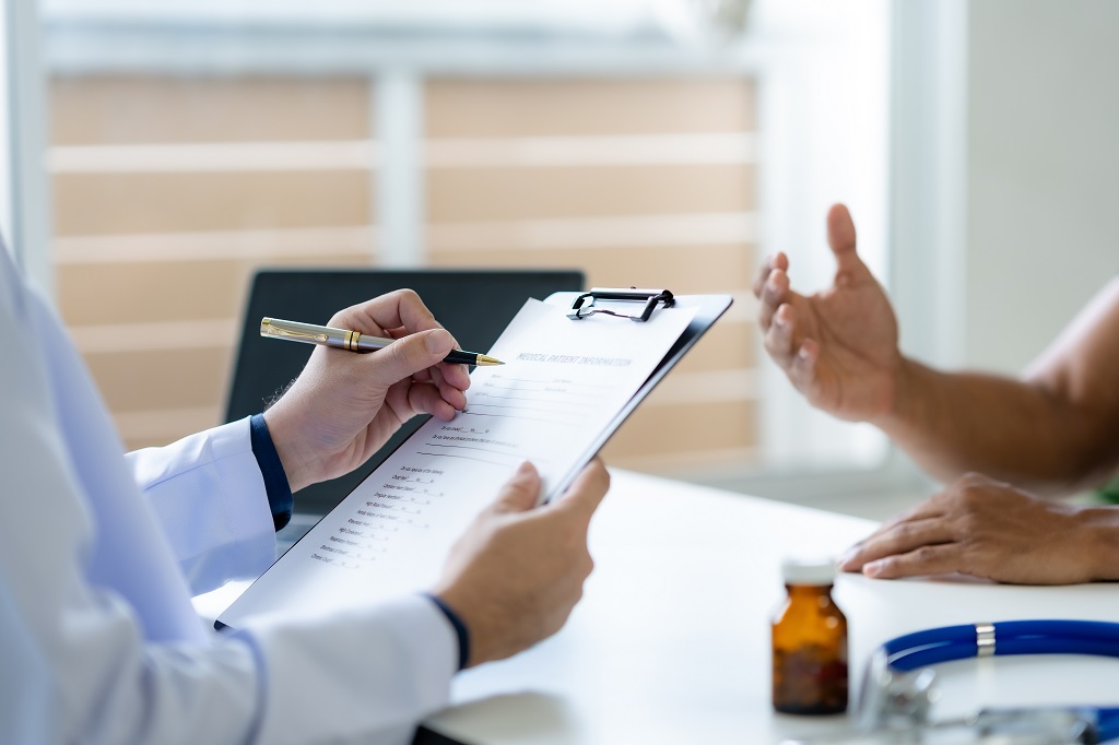 Doctor reviewing medical eligibility paperwork with a patient during a healthcare consultation