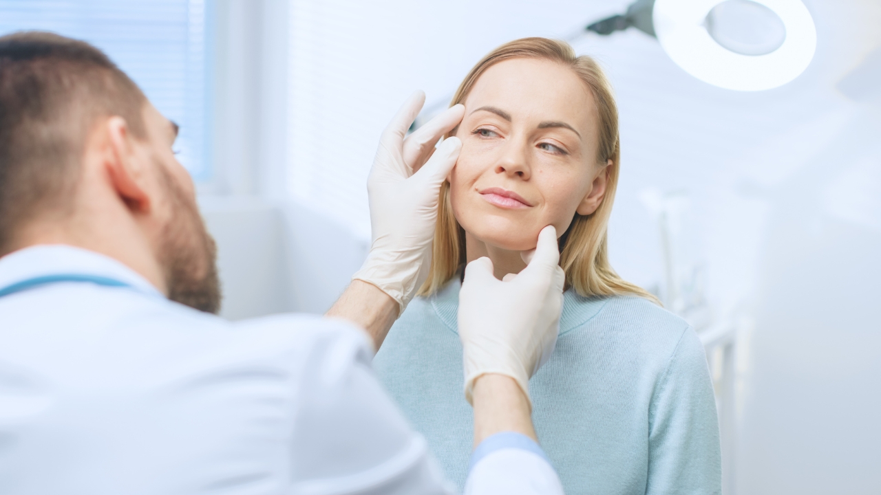 Clinician checks a woman’s face before a cosmetic procedure