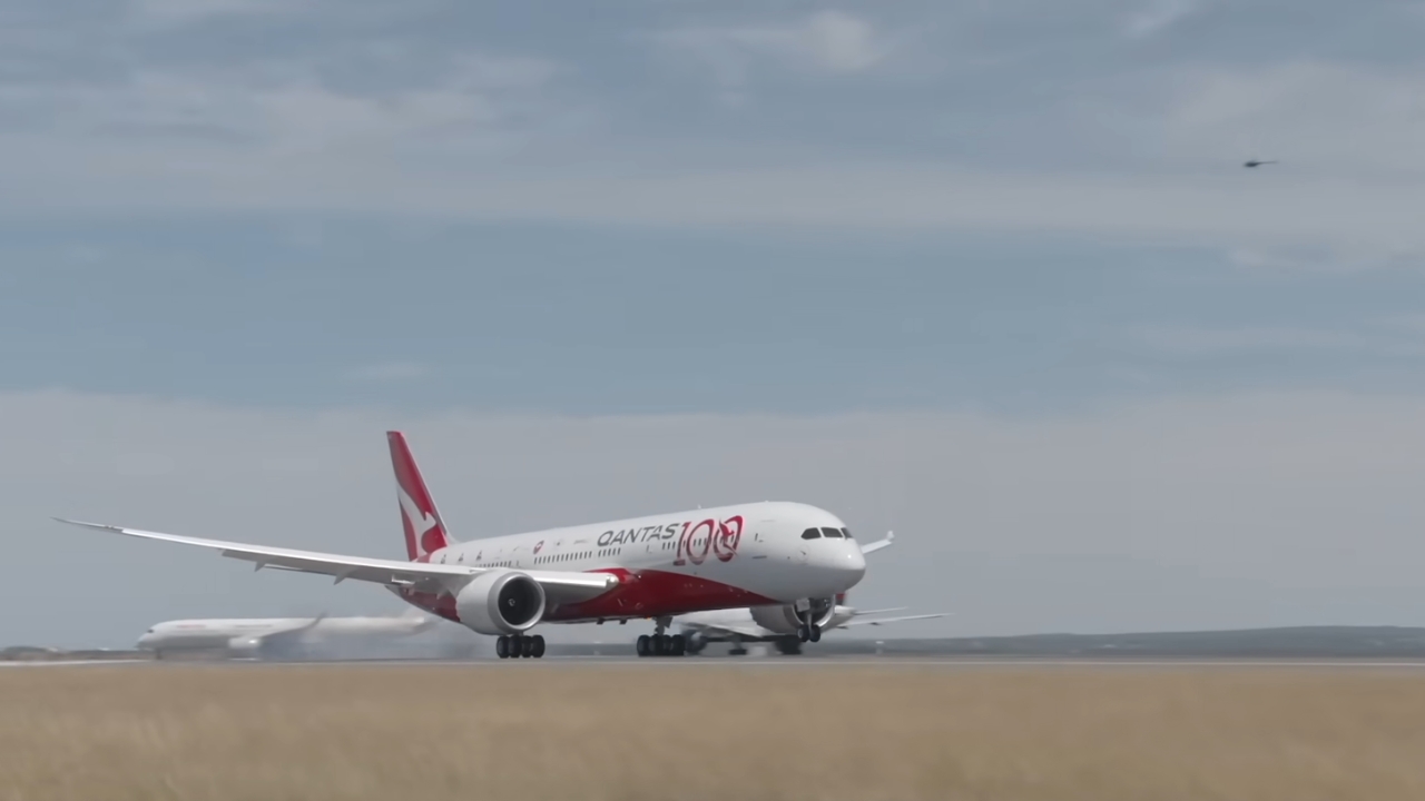 Qantas aircraft on a runway under a cloudy sky