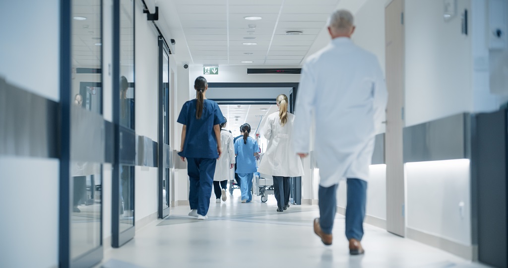 Healthcare professionals walking through a hospital corridor during routine patient care operations