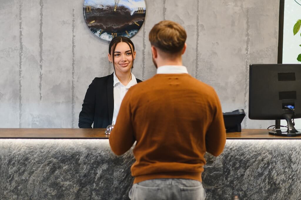 Hotel guest speaking with a front desk receptionist during the check-in process