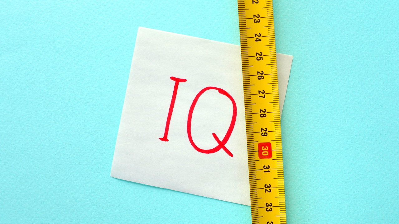 IQ note beside a yellow ruler on a blue surface
