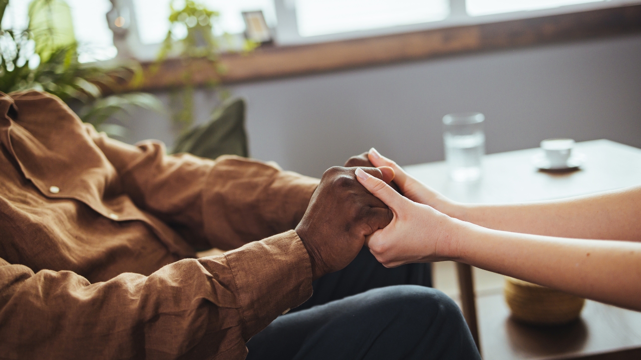 Caregiver supports a person with Parkinson's disease at home