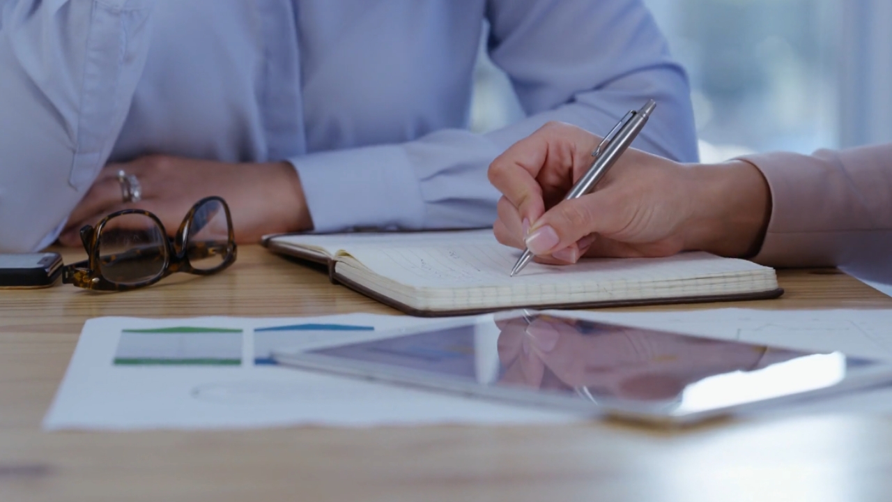 A person takes notes during a health policy meeting