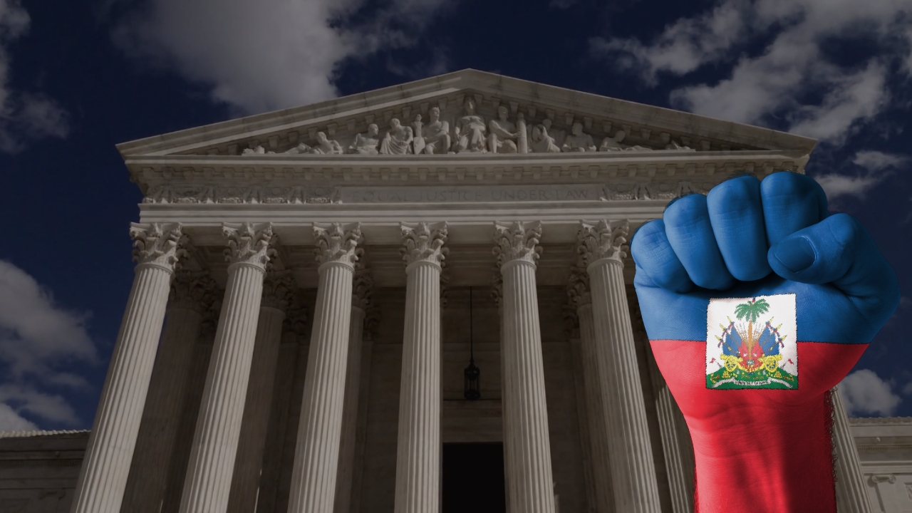 A fist painted with Haitian flag colors is raised in front of the U.S. Supreme Court