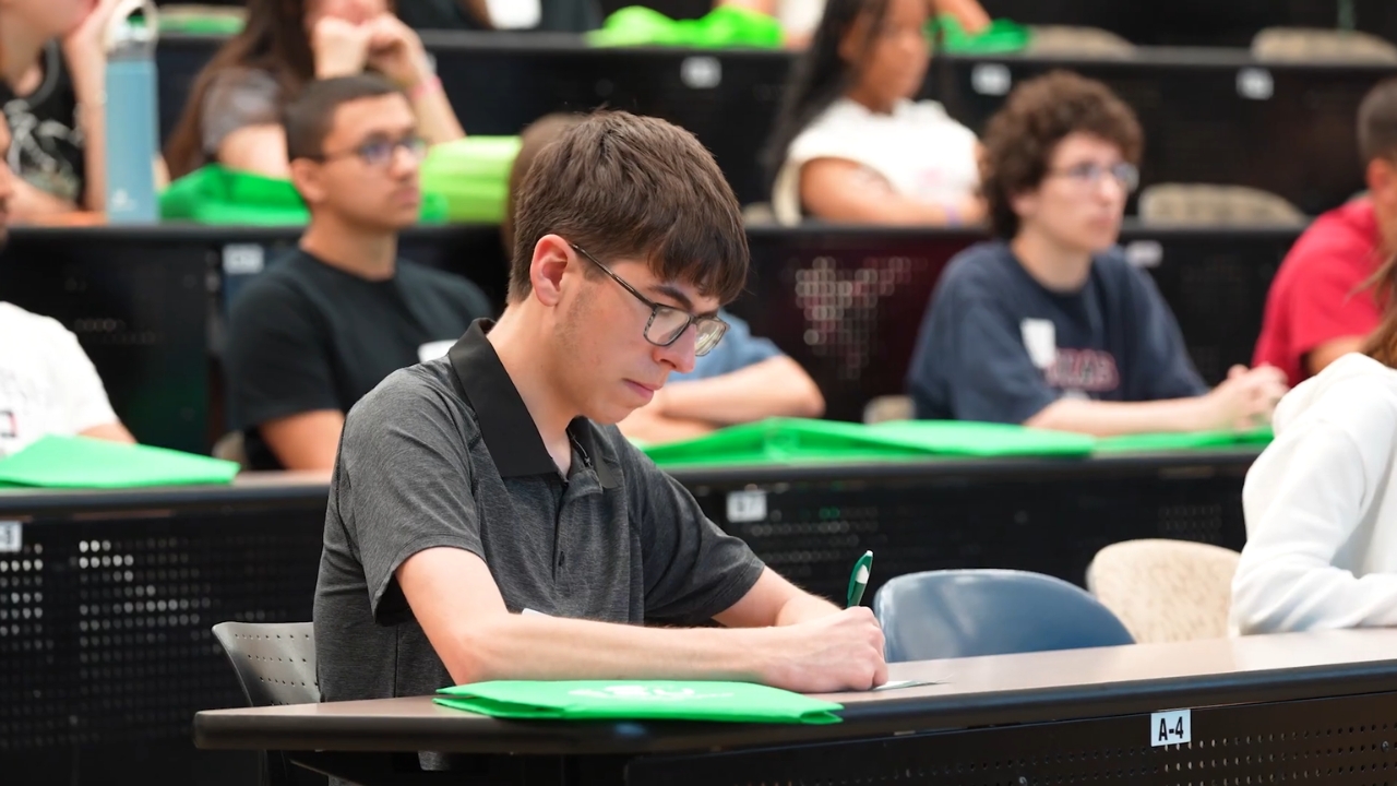 A Cleveland State student takes notes in a crowded classroom