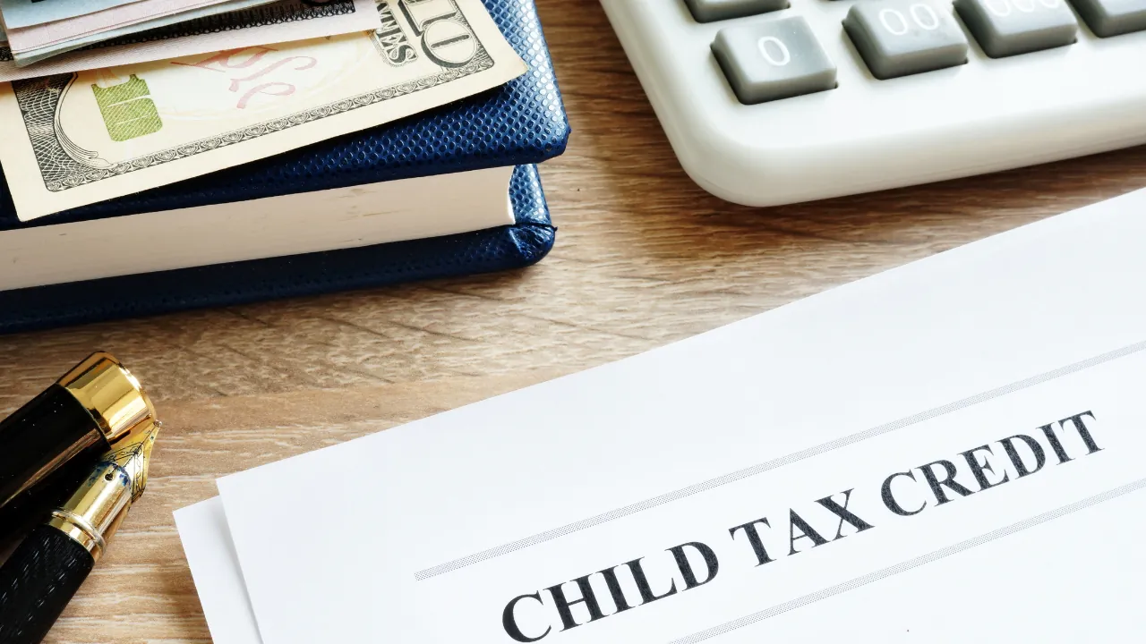 A Child Tax Credit form sits beside cash and a calculator