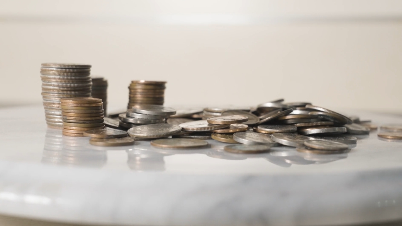 Stacks of coins and loose change sit on a white table