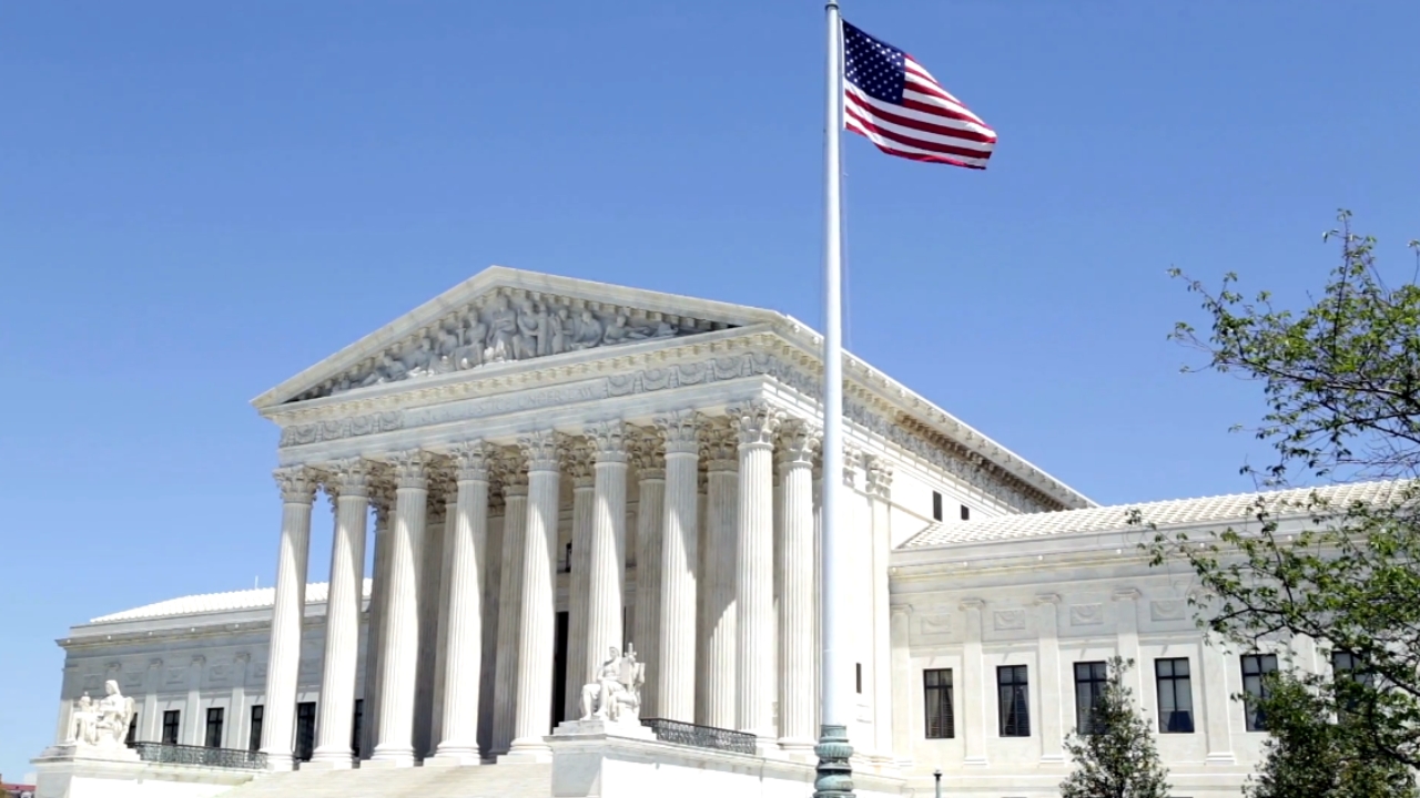 The U.S. Supreme Court building stands behind an American flag
