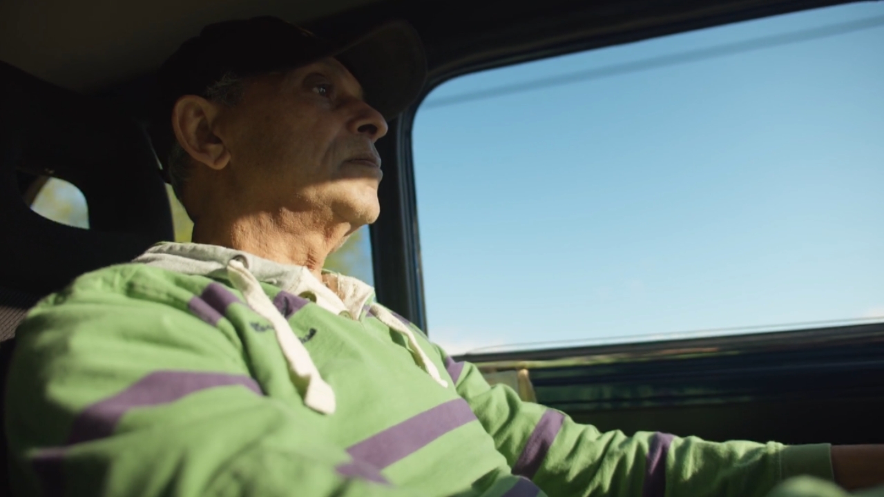 Older man drives a car on a sunny day