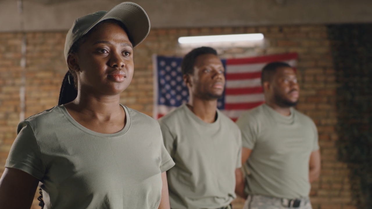 Three U.S. military reservists stand before an American flag