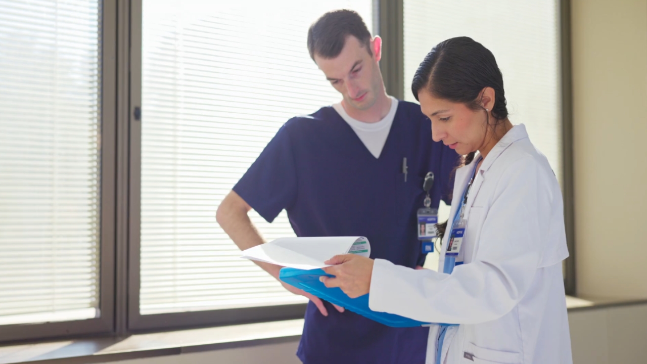 Two medical workers review patient paperwork in a clinic