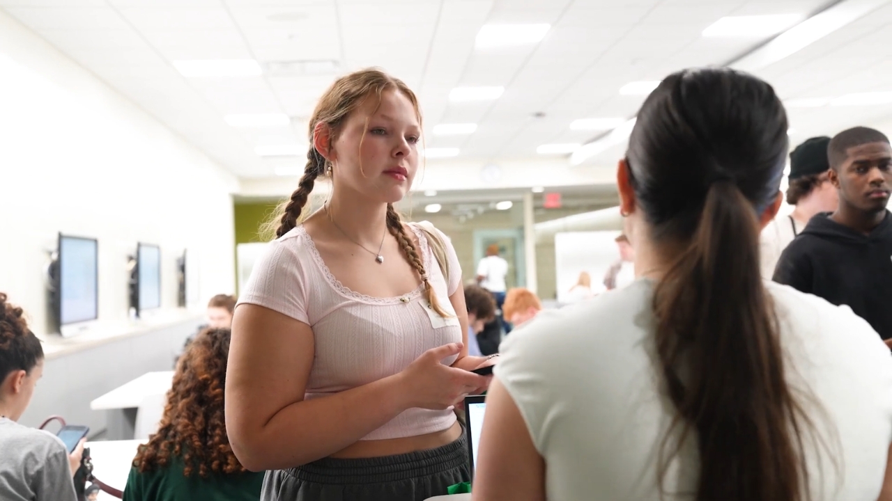 A Cleveland State student talks with a staff member at a busy campus event
