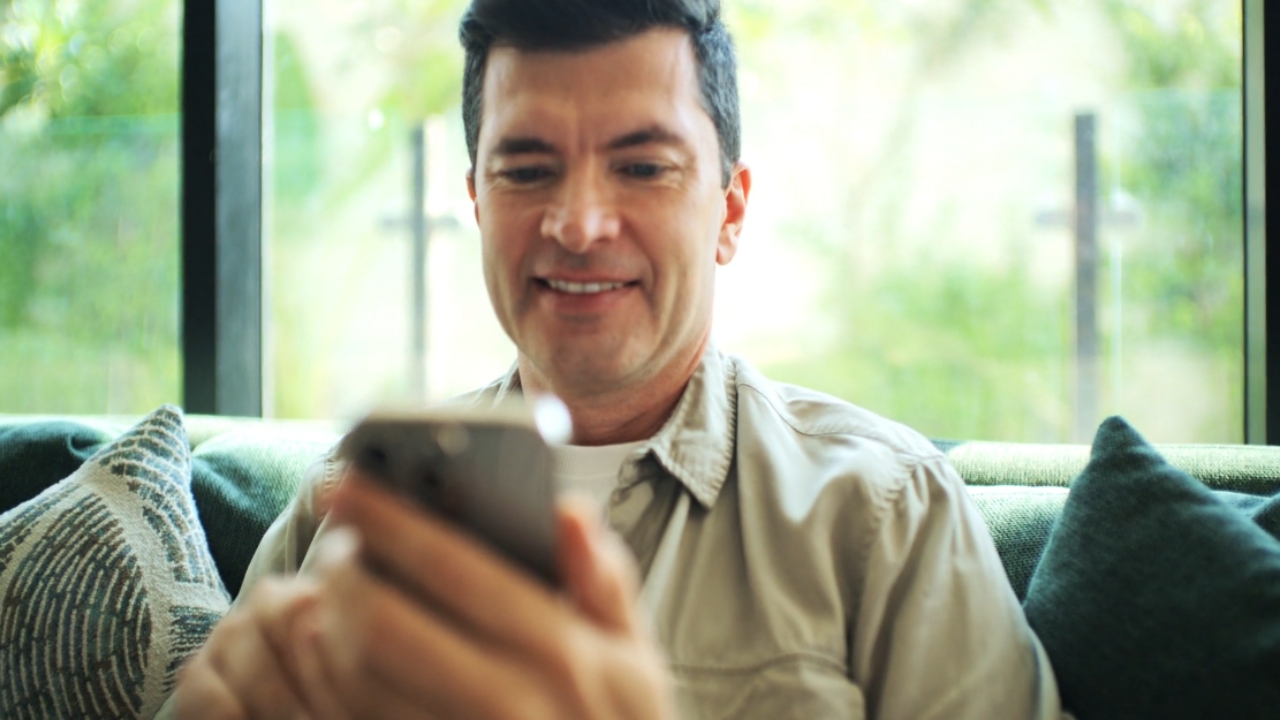 Man uses a smartphone on a couch