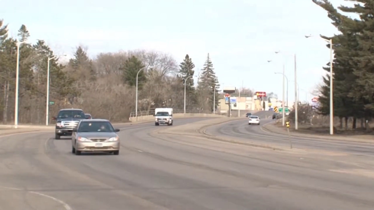 Cars travel along a wide Minnesota road on a clear day