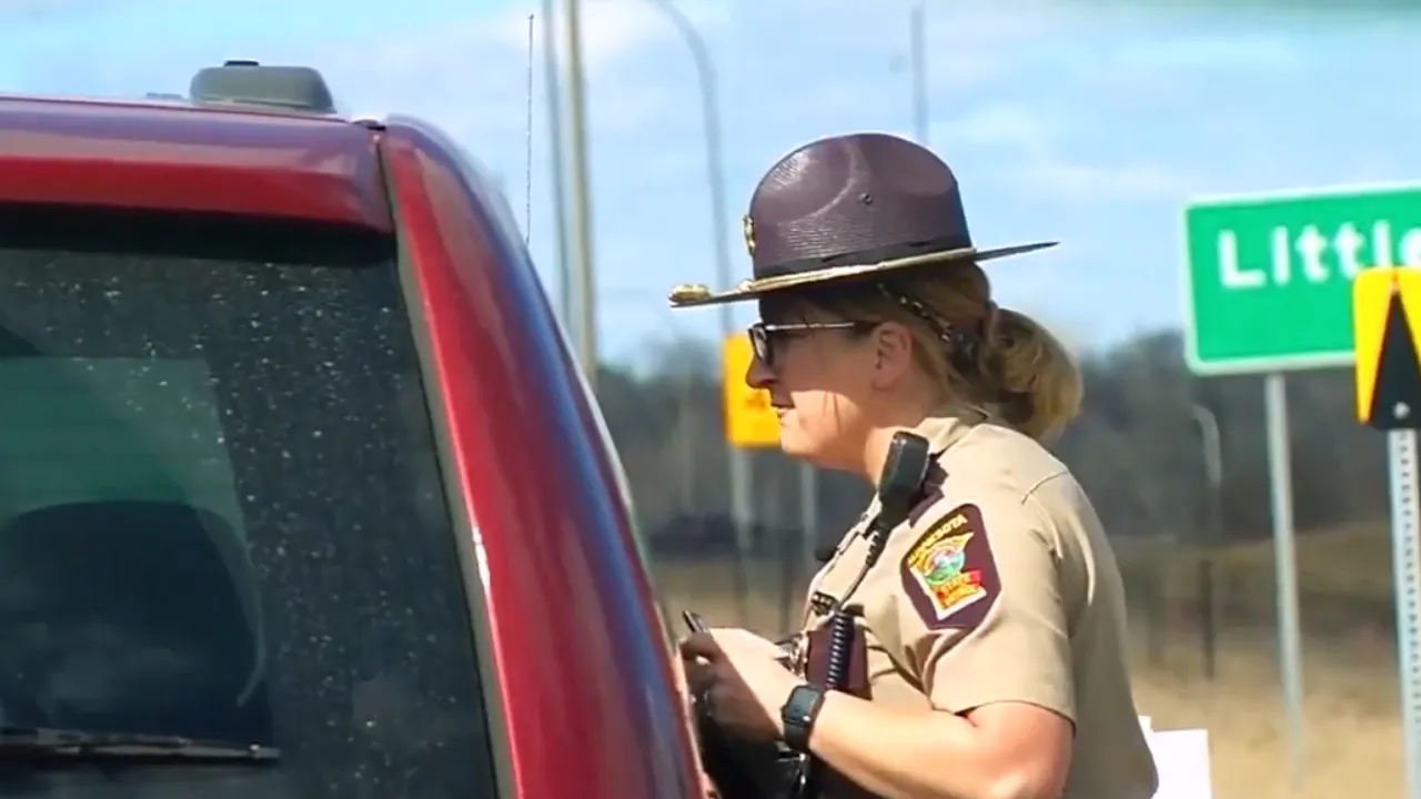 A Minnesota State Patrol officer speaks with a driver at a roadside traffic stop
