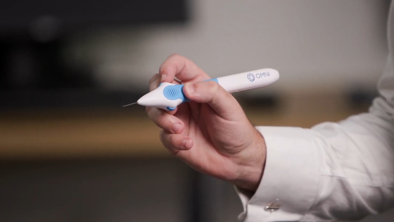 A surgeon holds the OMNI glaucoma surgical device