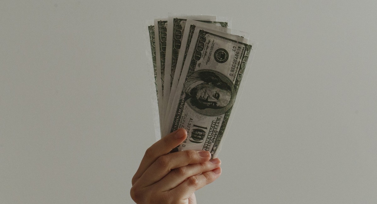 An image of a hand holding cash, visualizing the upcoming social security payments in September 2026