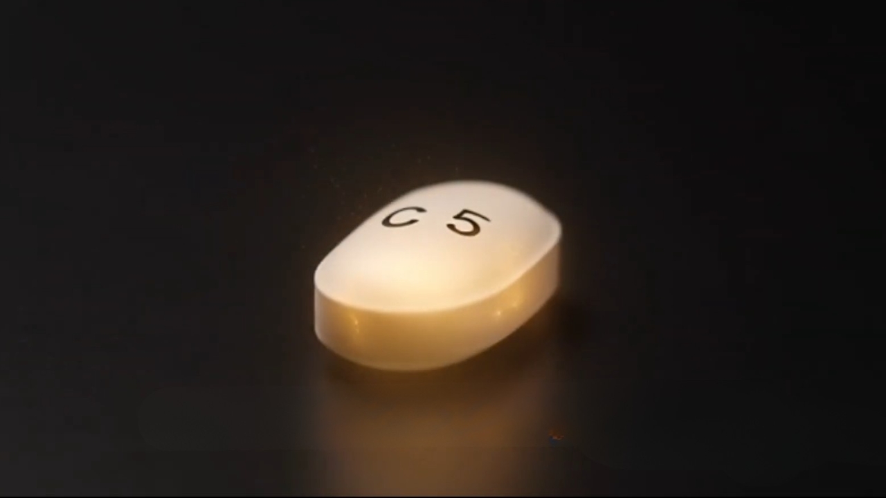 Close-up of a white Cialis 5 mg tablet on a dark surface