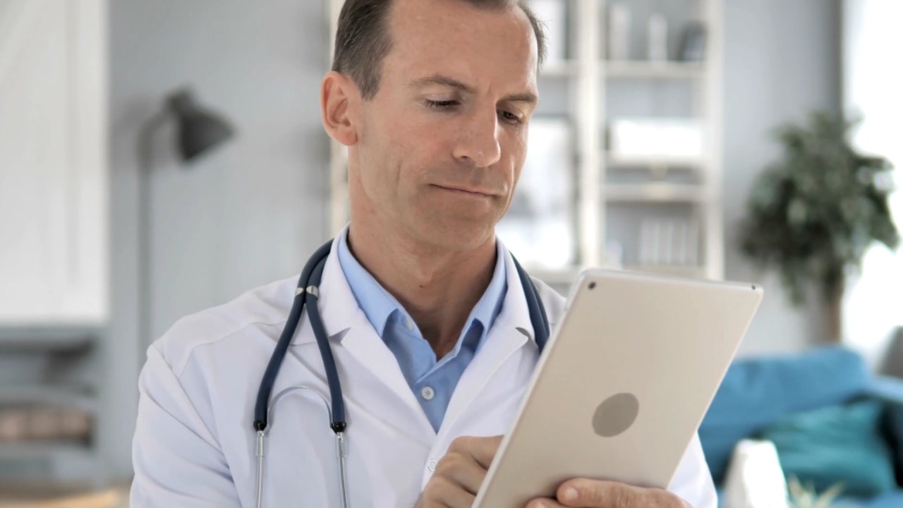 Doctor checks a patient portal on a tablet