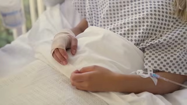 Patient resting in a hospital bed with an IV line
