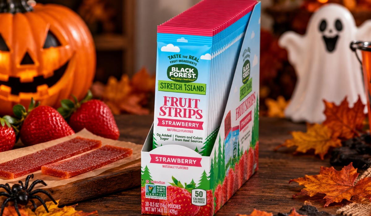 Stretch Island strawberry fruit strips in a display box with fresh strawberries, Halloween pumpkins, autumn leaves and spooky decorations.
